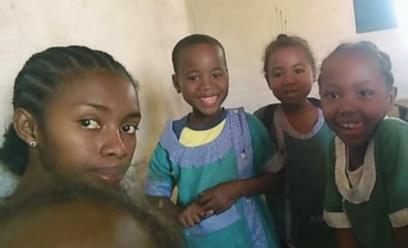Béatrice entourée de trois enfants en blouse d'école