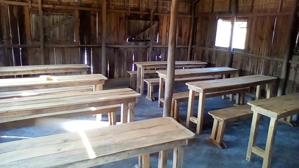 Tables et bancs en bois installés dans une salle de classe