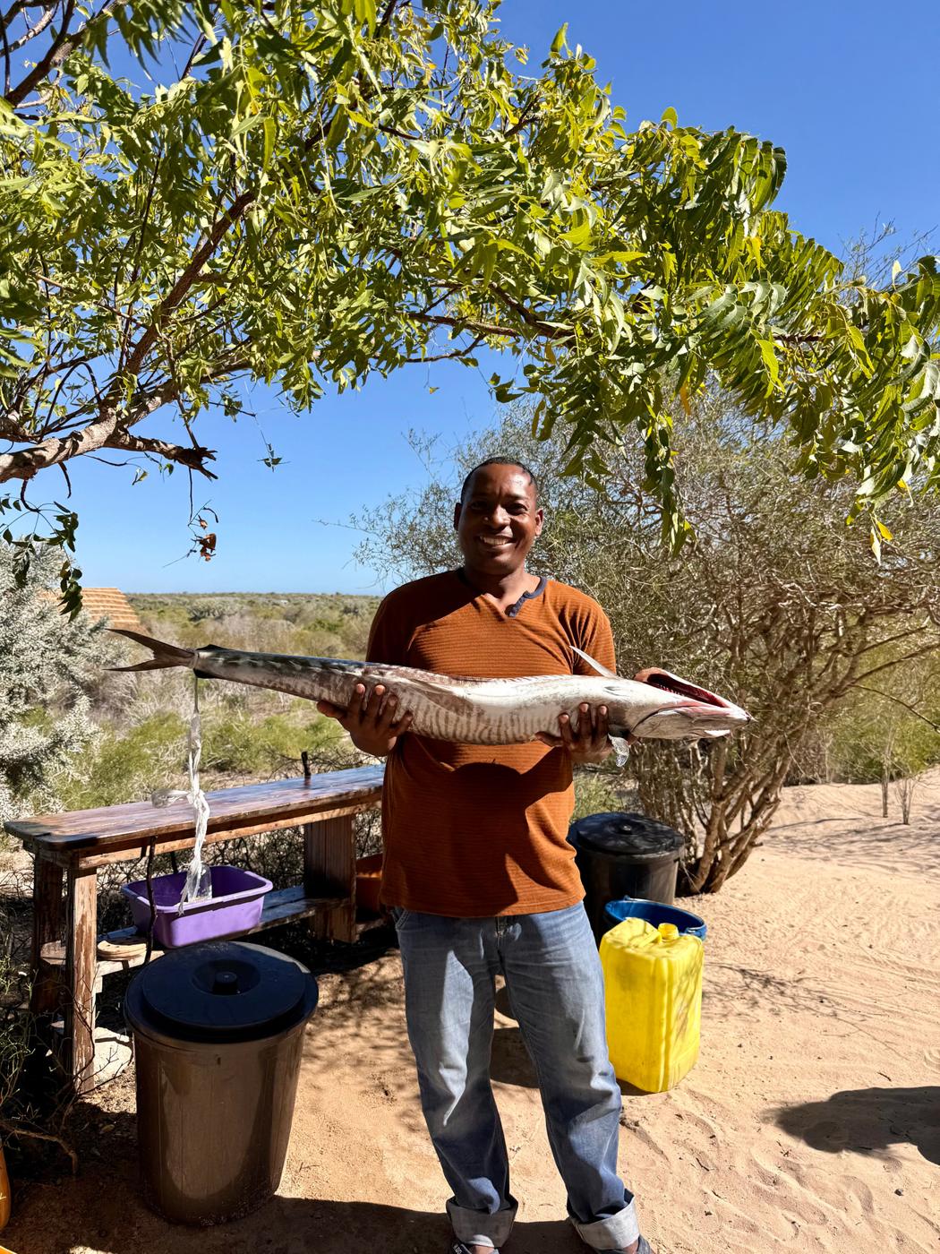 Sazy, souriant, tenant un grand poisson